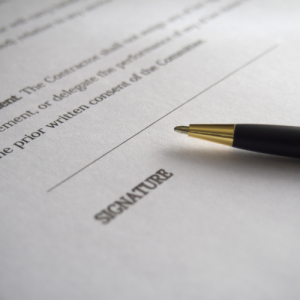 Close-up of a contract signature line with a black and gold pen.